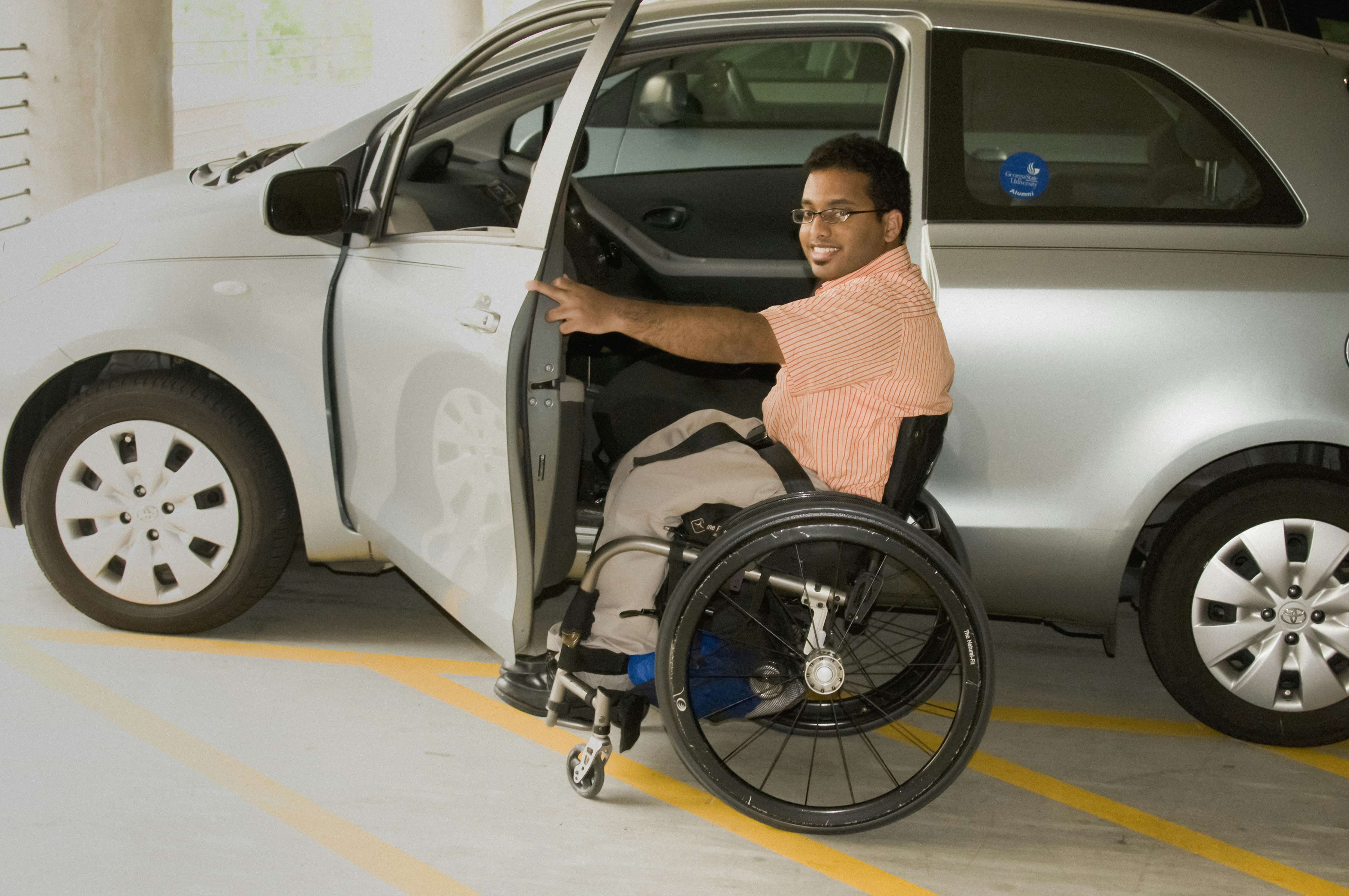 Wheelchair user preparing for a car transfer in a parking area
