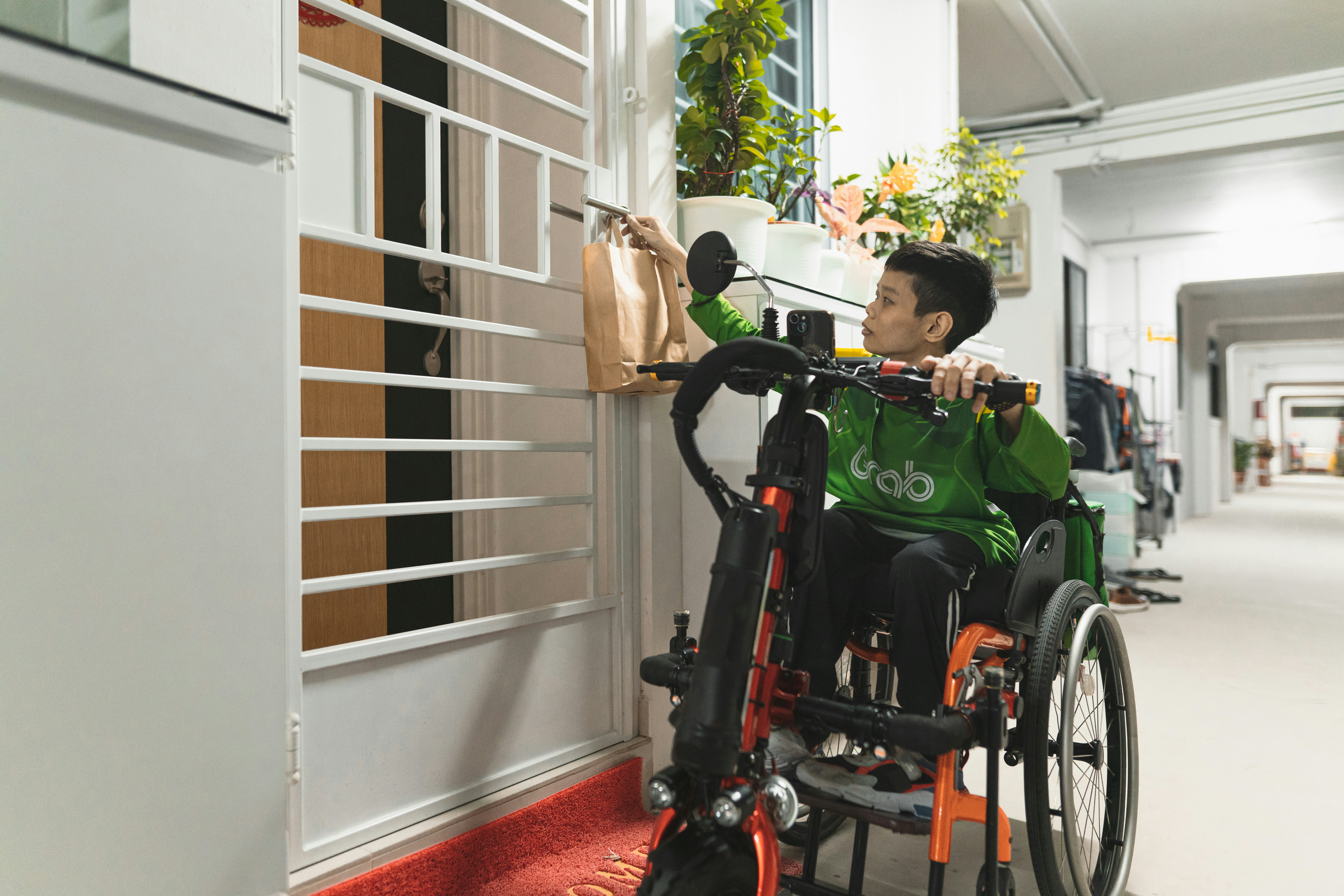 Wheelchair user reaching an apartment gate during a delivery