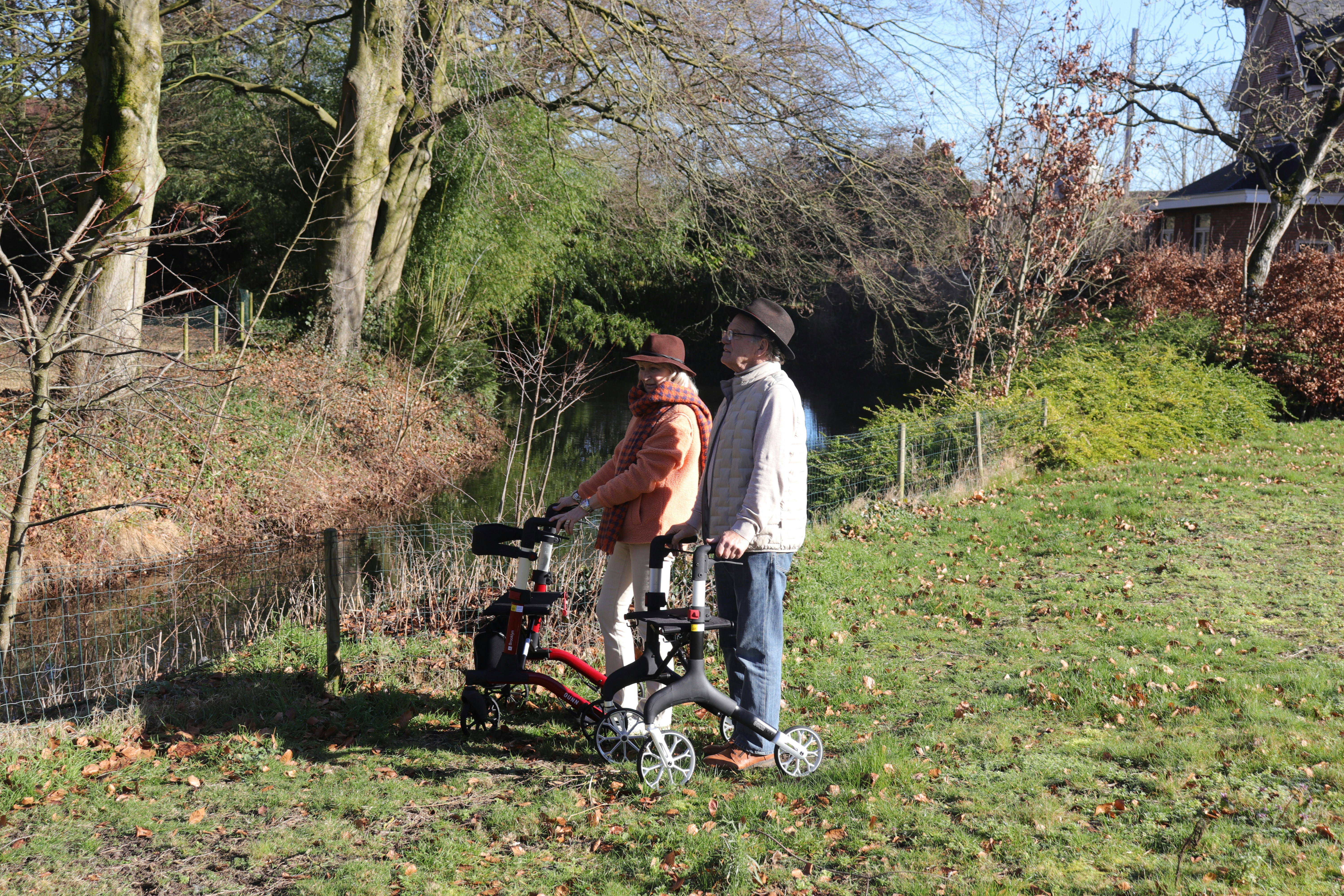Two people using rollators beside a pond