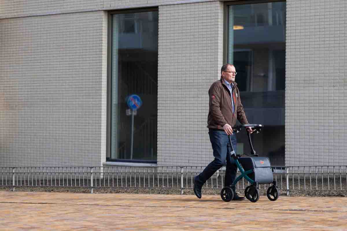 a man walking with a stroller in front of a building