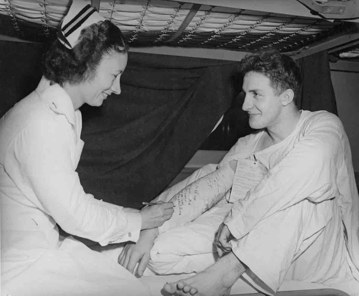 Nurse gives injection to patient in bed.